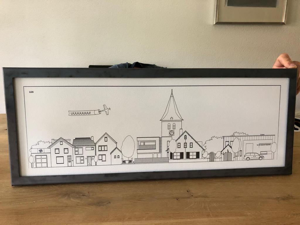 Ingelijste Line met een dorpsgezicht, kerktoren en een vliegtuigje met banier